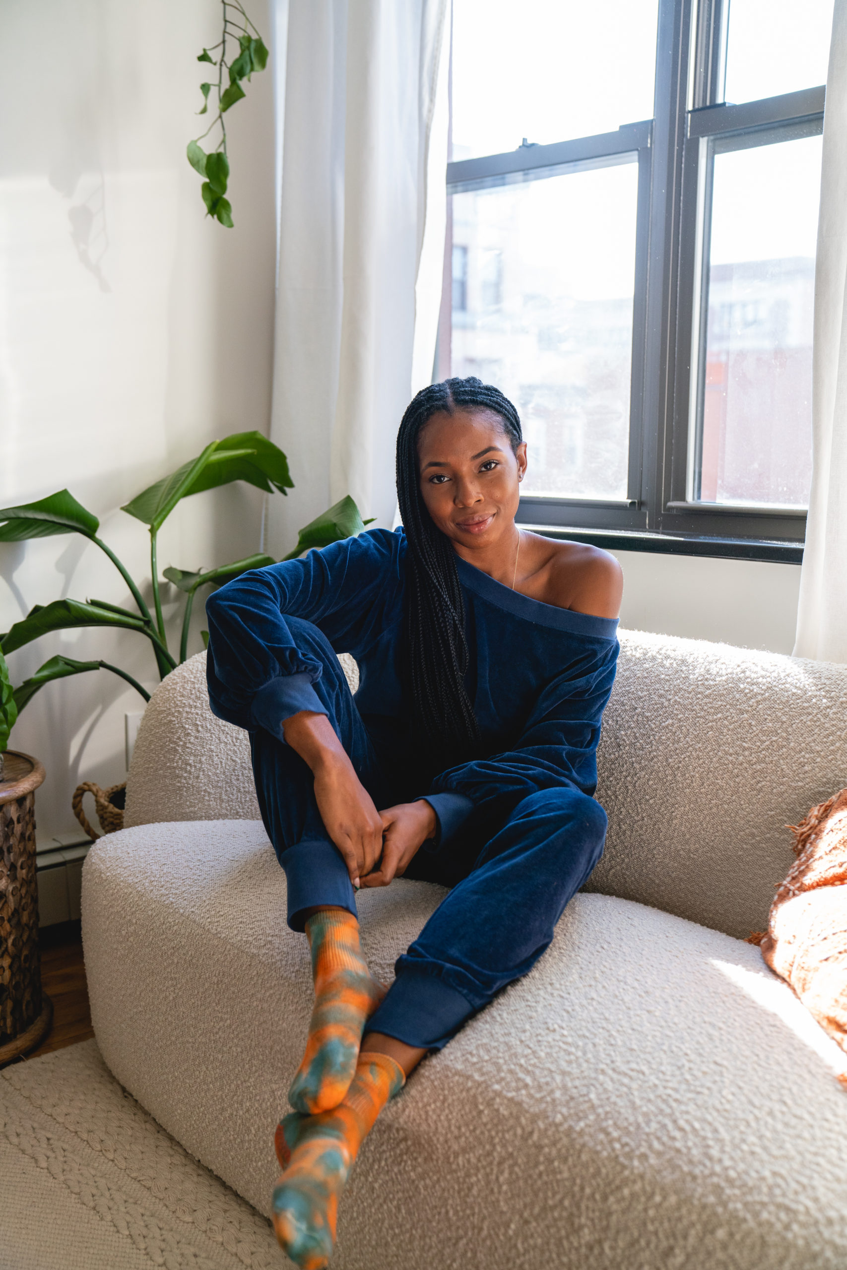 Kira West Seated on couch with blue sweat suit