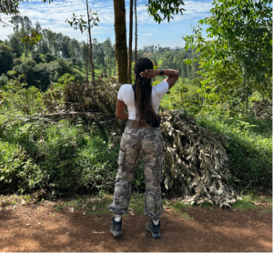 girl standing in front of green foliage